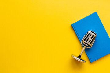 Flat lay of microphone and book. Record an audiobook or podcast concept