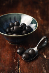 black olives on a spoon and in a bowl