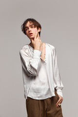 Fototapeta premium Fashion portrait of stylish high fashionable boy posing isolated over grey background. Concept of modern fashion, uniqueness, ad