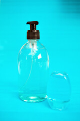 Plastic bottle of the blue transparent liquid soap and a pocket antiseptic gel isolated over the blue background 