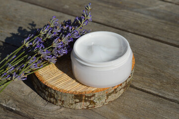 Obraz na płótnie Canvas organic lavender flowers, moisturizer cream on wooden background. The concept of beauty and wellness. Skincare and body