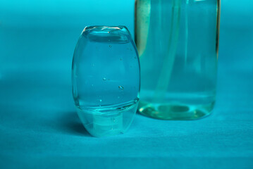 Plastic bottle of the blue transparent liquid soap and a pocket antiseptic gel isolated over the blue background 