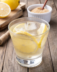 Brazilian sicilian lemon caipirinha in a glass with ice and fruits over wooden table