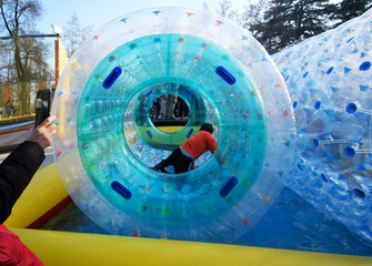 children playing inside bubble having fun in the Luna Park - Amusement Park Ride