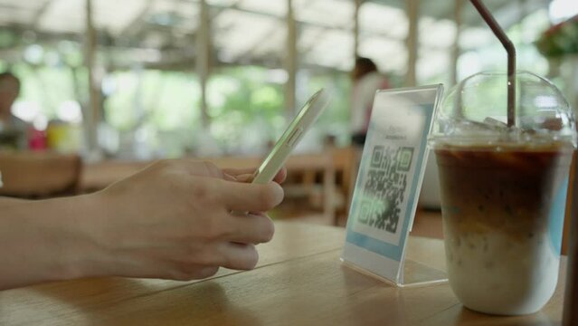 Woman use smartphone to scan QR code to pay in cafe restaurant with a digital payment without cash. Choose menu and order accumulate discount. E wallet, technology, pay online, credit card, bank app.