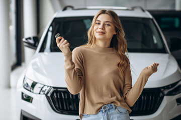 Woman holding keys by her new car