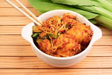 Fried dumplings in a white bowl. Made from wet dumplings that are sauteed with mustard greens, bean sprouts and spicy seasonings