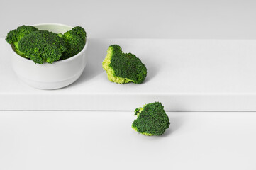 Fresh raw broccoli in a white bowl on a white background. Cooking healthy food.