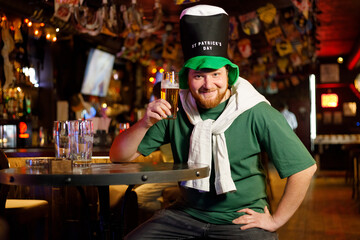 ginger man in leprechaun hat for st patrick's day raises a rouse