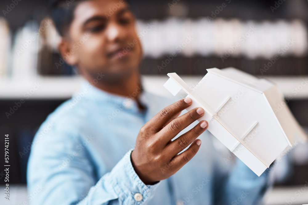 Poster say hello to your new home. shot of a young architect designing a building model in a modern office.