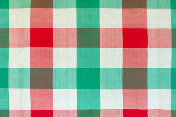 Red and green checkered tablecloth as background, closeup of photo