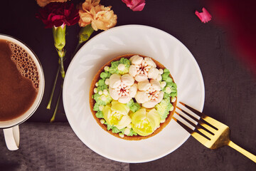 Feminine floral hygge aesthetic - french tart, petals coffee among flowers flat lay. Desserts using the trend Dreamy Escapism.