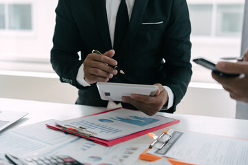 Business people are deeply examining financial reports for investment returns or investment risk...
