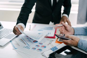 Business people are deeply examining financial reports for investment returns or investment risk analysis.