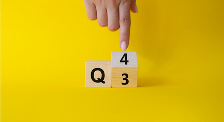 From 3rd Quarter to 4th symbol. Businessman hand points at turned wooden cubes with words 3rd Quarter and 4th Quarter. Beautiful yellow background. Business and Quarter concept. Copy space