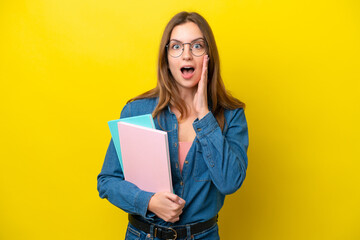 Young student caucasian woman isolated on yellow background with surprise and shocked facial...
