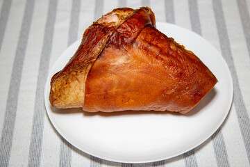 Smoked pork knuckle, traditional German dish, isolated portrait and in selective focus