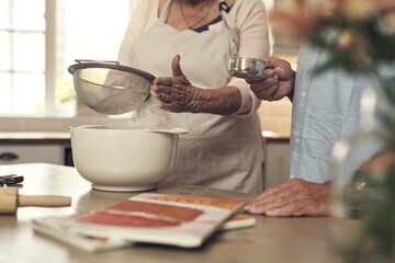 I always have help by my side. Shot of an unrecognizable couple baking together at home.