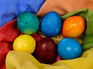 Colorful dyed Easter eggs lie in a basket on the colorful textile napkins