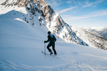 Fototapeta na wymiar Skitouring with amazing view of famous mountains in beautiful winter powder snow of Alps