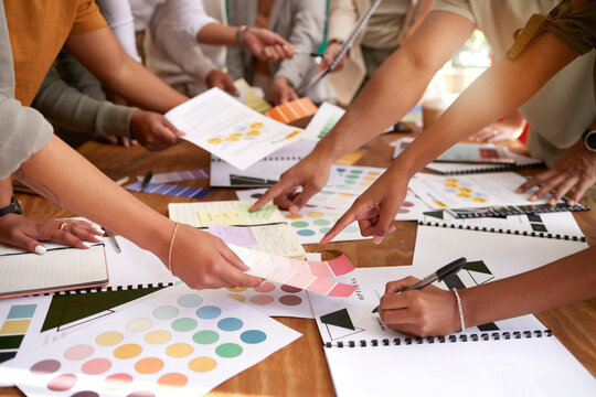 Color design, creative and hands of business people on desk for branding meeting, strategy and marketing logo. Teamwork, collaboration and designers brainstorming ideas, thinking and project plan