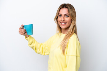 Naklejka premium Young Uruguayan woman holding cup of coffee isolated on white background smiling a lot