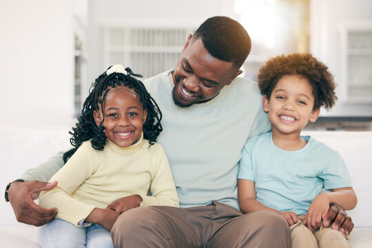 Love, happy and father on a sofa with his children embracing, relaxing and bonding in the family home. Happy, smile and portrait of kids sitting with their dad in the living room of their house.