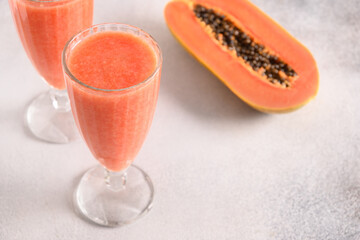 Papaya lassi or smoothie on gray background. Freshness cold beverage made of yogurt, water, spices,...