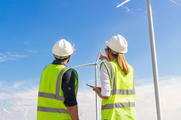 engineer team working in wind turbine farm. Renewable energy with wind generator by alternative...