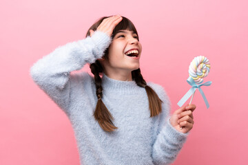 Little caucasian girl holding a lollipop smiling a lot