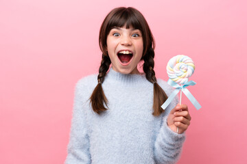 Little caucasian girl holding a lollipop with surprise facial expression