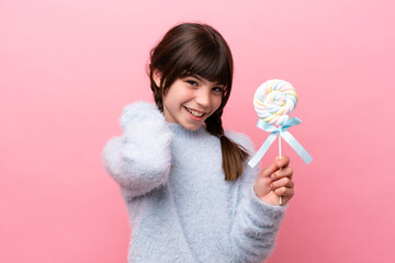 Little caucasian girl holding a lollipop laughing