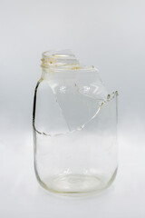 Broken glass jar closeup on white