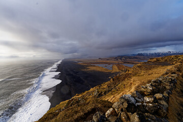 Plage Islandaise de sable noir avec une mer agitée prise de haut au couché du soleil 