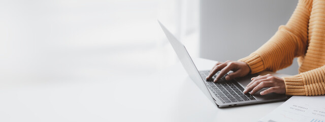 Person typing on laptop keyboard, businessman working on laptop, he is typing messages to...