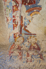 Remains of an early Orthodox fresco on the wall of an unknown abandoned cave church in Cappadocia, Turkey, Faces of saints scratched by representatives of another religion