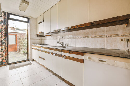 Interior of kitchen with white cupboards with wooden elements