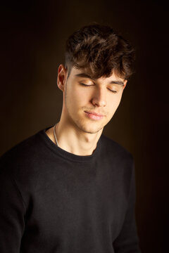Calm teenager with closed eyes in dark room
