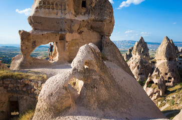 Cave village in Cappadocia, Tourist standing in the archway of the ruins of an ancient stone house...