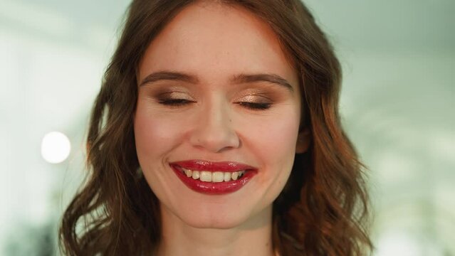 Young woman with professional makeup looks in camera smiling