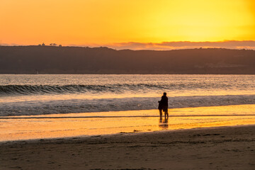 Fototapeta na wymiar Couple enjoying the sunset on Coronado beach, San Diego, California