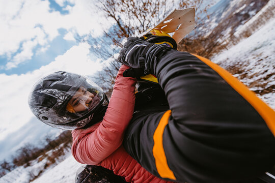 Couple Enjoying While Driving Quad Bike On Top Of Mountain At Winter Time