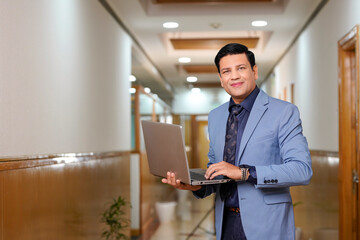 Indian businessman using laptop at office.