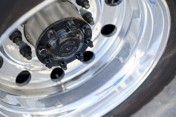 Silver tire rim with black hubcap and lug nuts