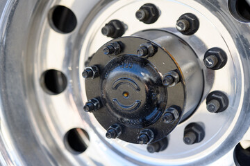 Silver tire rim with black hubcap and lug nuts