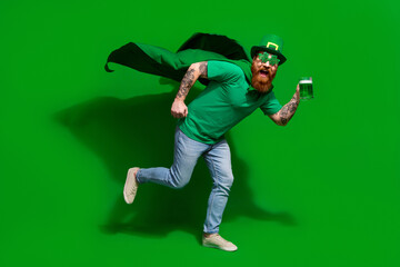 Full length photo of cool excited man wear t-shirt headwear drinking ale beer glass enjoying shamrock day isolated green color background