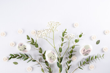 Easter composition made with flowers, eucalyptus branches and eggs on white background  copy space. Creative minimal holiday concept.