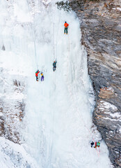 A group of people is Ice Climbing in Graubuenden, Switzerland on a frozen waterfall. 