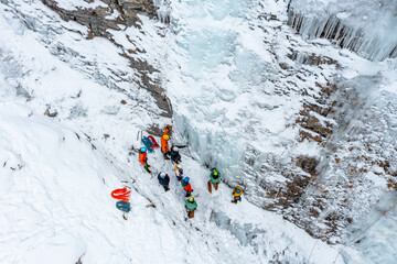 A group of people is Ice Climbing in Graubuenden, Switzerland on a frozen waterfall. 