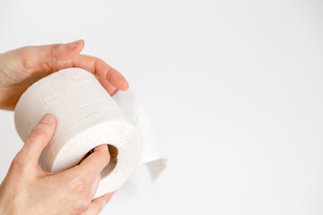 Closeup of person holding a recycled toilet paper roll in his hand over a white background. Environmental awareness and sustainable use concept. Minimalist idea. Copy space
